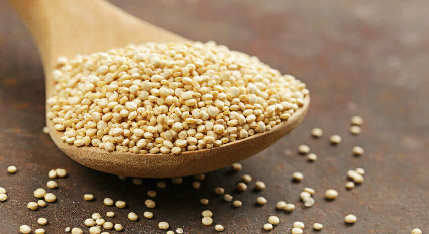 Natural organic cereal quinoa in a wooden spoon