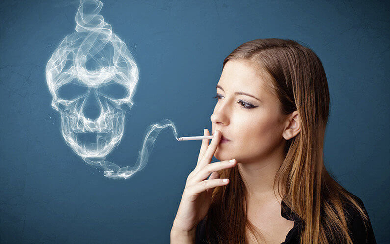 Pretty young woman smoking dangerous cigarette with toxic skull smoke