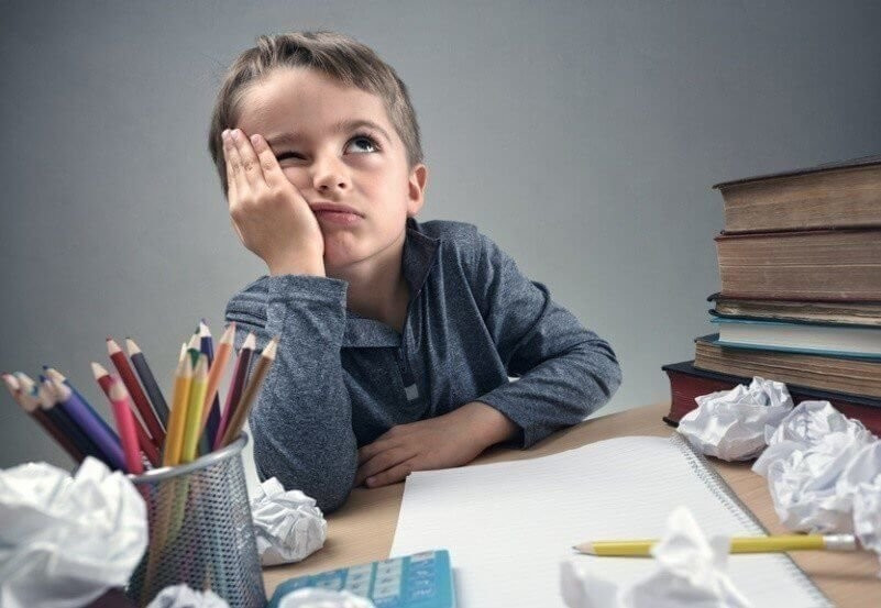 Bored and fed boy up doing his homework