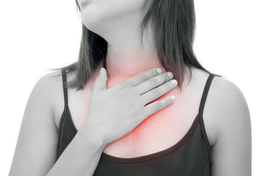 Woman suffering from acid reflux or heartburn, isolated on white background