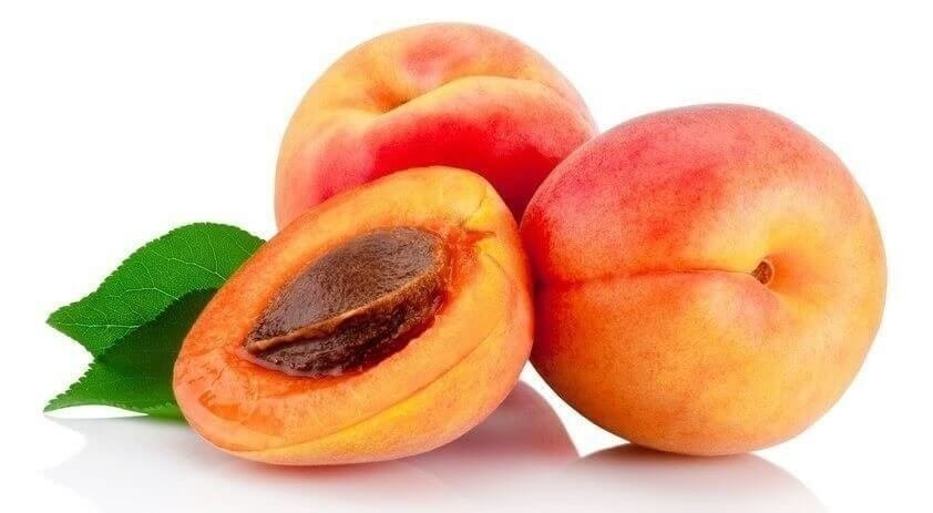 Fresh cut apricot fruits with leaf isolated on white background