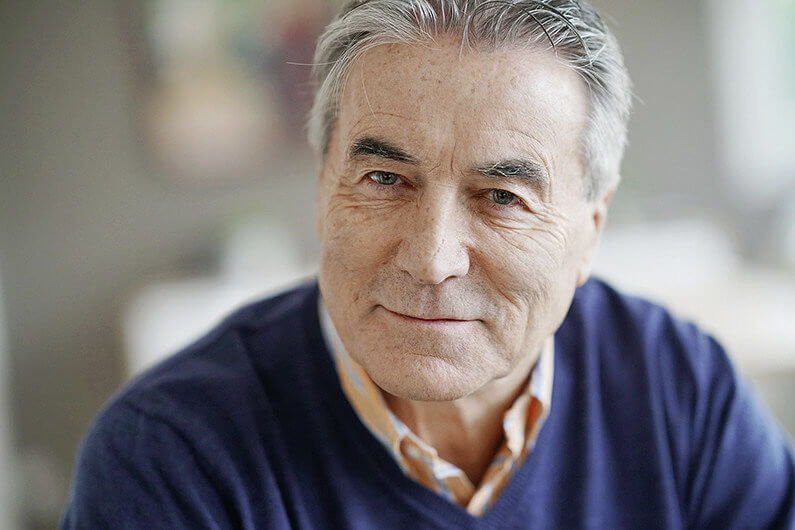 Portrait of senior man with blue sweater looking at camera