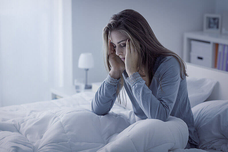 Depressed woman awake in the night, she is exhausted and suffering from insomnia