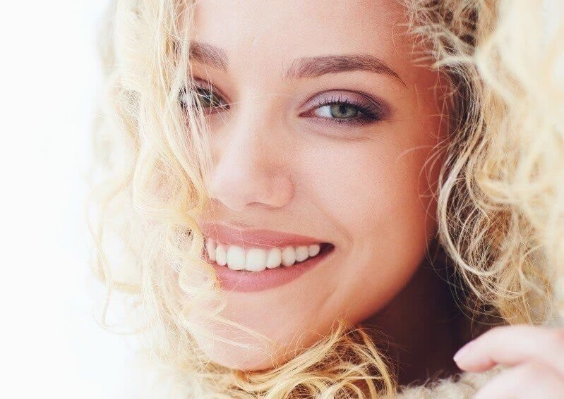 portrait of beautiful happy woman with curly hair and adorable smile