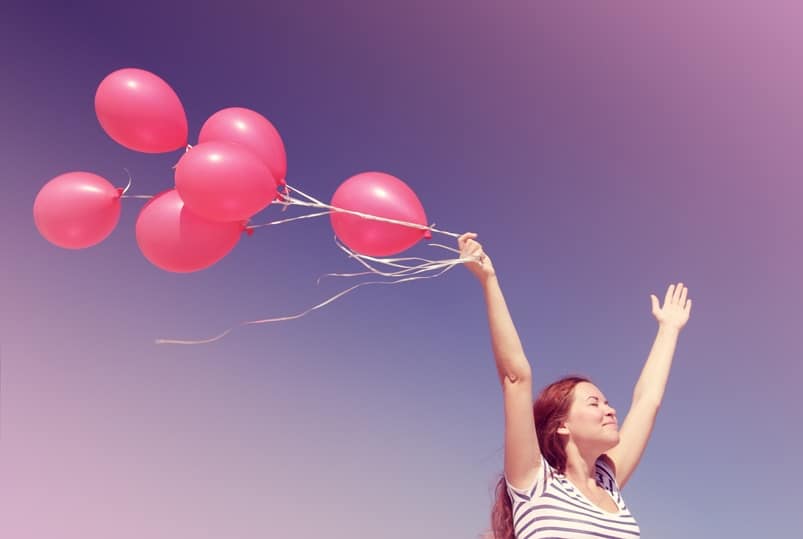 Young woman holding red balloons. Photo in old color image style.