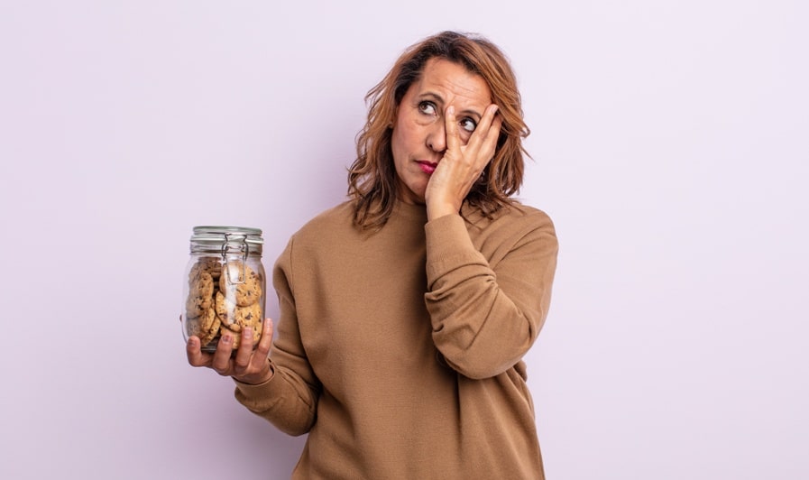 pretty middle age woman feeling bored, frustrated and sleepy after a tiresome. homemade cookies concept