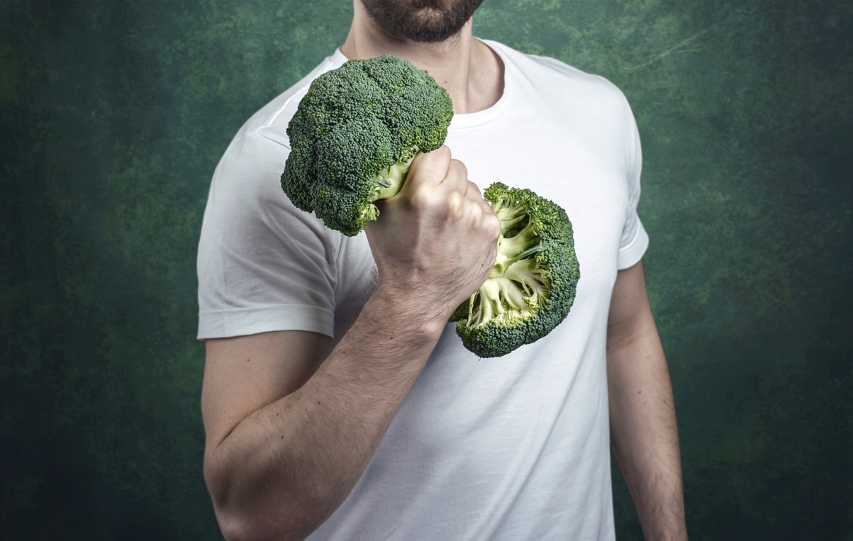 Mann trainiert mit Gemüse