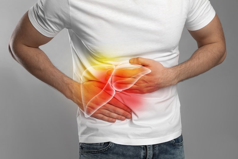 Man suffering from liver pain on grey background, closeup