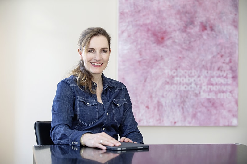 Gabriela Taugwalder sitzt an einem Tisch in ihrem Büro