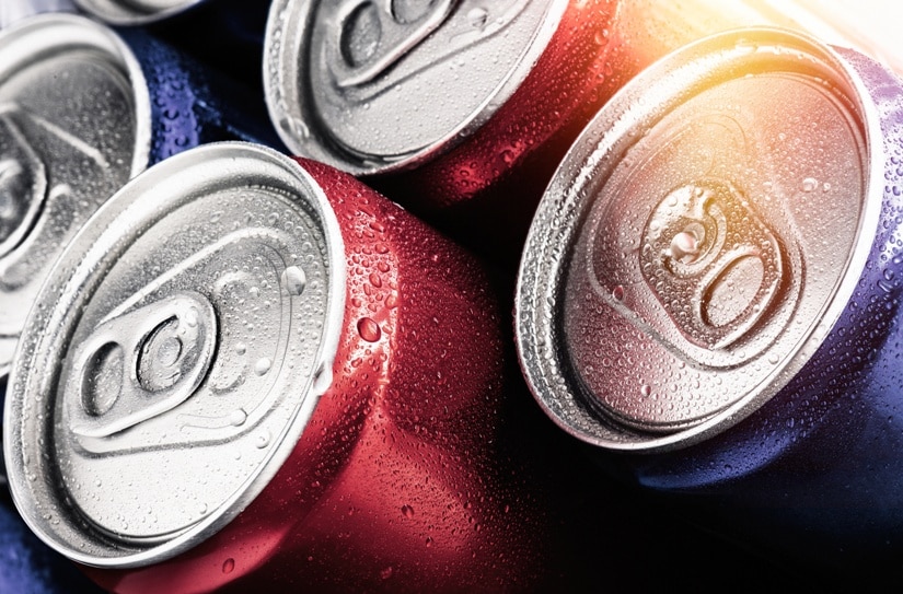 Red and blue cans of soft drinks with water drops.