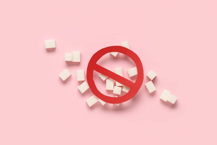 Sugar cubes with stop sign on pink background