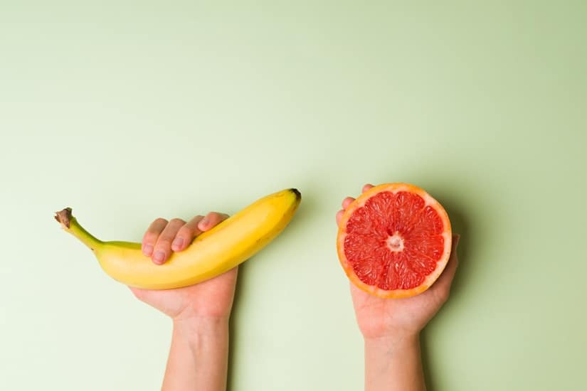 Caucasian person using fruit for sex education